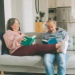 Happy married couple sitting on a couch having a good time.