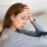 A woman sitting on the floor and wondering if she's the problem in her relationship.