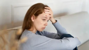 A woman sitting on the floor and wondering if she's the problem in her relationship.